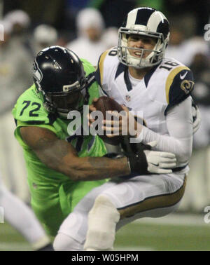 Michael Bennett (72) of the Seattle Seahawks loses his helmet as he tackles  Eddie Lacy (27) of the Green Bay Packers in the NFC Championship game at  CenturyLink Field in Seattle, Washington