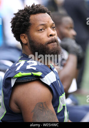 Michael Bennett (72) of the Seattle Seahawks loses his helmet as he tackles  Eddie Lacy (27) of the Green Bay Packers in the NFC Championship game at  CenturyLink Field in Seattle, Washington