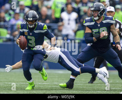 Seattle Seahawks quarterback Russell Wilson (3) runs away from Los Angeles Rams defensive tackle Aaron Donald (99) during the fourth quarter at CenturyLink Field on October 7, 2018 in Seattle, Washington. The Rams beat the Seahawks 33-31.      Photo by Jim Bryant/UPI Stock Photo