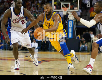 Golden State Warriors guard Baron Davis (C) drives towards the basketball hoop past Los Angeles Clippers forward Tim Thomas (2) in the fourth quarter at the Oracle Arena in Oakland, California on March 09, 2007. (UPI Photo/Aaron Kehoe) Stock Photo