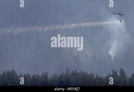 A fire helicopter dumps flame retardent on a hot spot of the Angora Fire in South Lake Tahoe, California on June 27, 2007. The Angora Fire has burned approximately 2700 acres in South Lake Tahoe and 55 percent contained.   (UPI Photo/Aaron Kehoe) Stock Photo