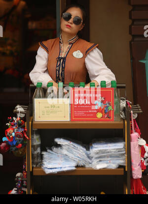 A Chinese saleswoman waits for customers at a gift kiosk in Shanghai Disneyland Resort on August 14, 2017.  Shanghai Disneyland is the company's largest foreign investment and is targeting China's rapidly growing middle class - a key to the company's future, according to Disney.       Photo by Stephen Shaver/UPI Stock Photo