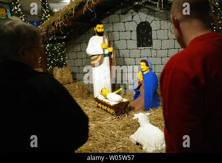 Visitors to the National Shrine of Our Lady of the Snows' Way of Lights Lego exhibit in Belleville, IL, look at the estimated one million Lego pieces it took to build this nativity scene on December 22, 2003.The nativity scene took a dozen people working 24 hours a day over nine months to build. The scene is part of a Christmas display featuring all items built from Legos.  (UPI Photo/Bill Greenblatt) Stock Photo
