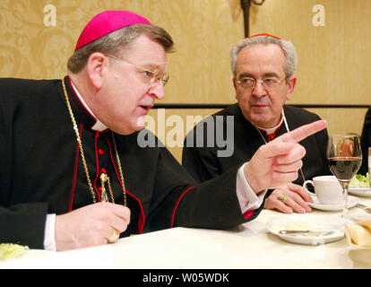 The new Archbishop of St. Louis, Raymond Burke (L) talks with the former Archbishop of St. Louis Cardinal Justin Rigali of Philadelphia, during a dinner in St. Louis on January 26, 2004.  Burke , the ninth Archbishop comes to St. Louis from La Cross , Wisconsin where he recently asked his priests not to deliver communion to those who may be pro-choice.   (UPI Photo/Bill Greenblatt) Stock Photo