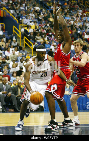 Cleveland Cavaliers LeBron James (L) ltries to cut to the inside as Chicago Bulls Eddie Curry (C) and Andres Nocioni defend in the first quarter during an exhibition game at the Savvis Center in St. Louis on October 16, 2004. (UPI Photo/Bill Greenblatt) Stock Photo