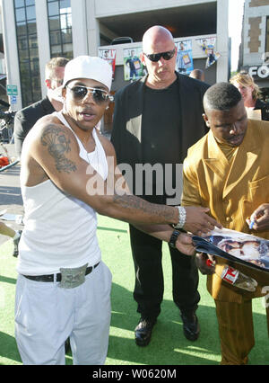 Rapper Nelly (L) stops to sign an autograph for a fan as he walks down the red carpet during a movie premier for the Longest Yard in University City, MO on May 22, 2005. Nelly, a St. Louis native, plays the part of a football player on a prison team.  (UPI Photo/Bill Greenblatt) Stock Photo