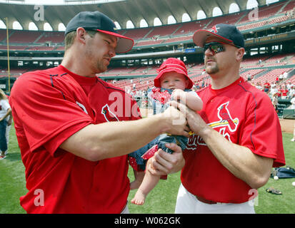 St. Louis Cardinals Scott Rolen (L) hands off his seven month daughter  Raine to teammate Larry Walker during the fathers/kids game before a game  against the Pittsburgh Pirates at Busch Stadium in