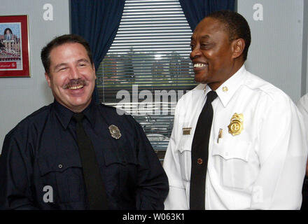 St. Louis firefighter John Heranadez (L) Is all smiles after Fire Chief Sherman George informs him that he has been awarded the Liberty Mutual National Firemark Award for Heroism in St. Louis on October 31, 2005. Hernandez of Engine Company 32 on the cities south side, is being honored for saving a three-year-old boy in a house fire in October 2004. Hernandez's nomination competed nationally with 25 other local award winners and was selected as the national award winner last month. The award, which will be officially given on November 4 at Walt Disney World in Florida, also comes with a $10 th Stock Photo