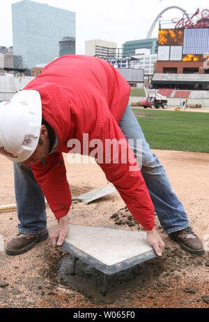 Head groundskeeper Bill Finley installs the homeplate at the new Busch Stadium in St. Louis on March 17, 2006. The homeplate is the same one used at the old Busch Stadium which the Cardinals played in for nearly 40 years. The St. Louis Cardinals will play their first game in the new facility on April 10. (UPI Photo/Bill Greenblatt) Stock Photo