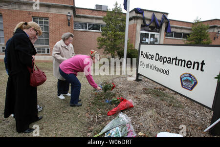 The family of a dead Kirkwood police officer place flowers outside the police department headquarters in Kirkwood, Missouri on February 8, 2008. Five people were shot dead and two injured when a gunman burst into a city hall meeting and begun shooting on February 7 Two other injuries included the mayor who was shot in the head and a newspaper reporter who was shot in the hand. Police shot and killed the gunman.       (UPI Photo/Bill Greenblatt) Stock Photo