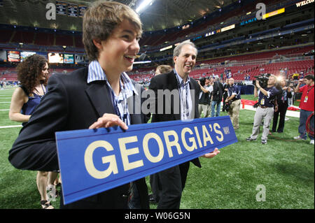 St. Louis Rams owner Chip Rosenbloom (R) looks at the sign son Alexander is holding before the Rams - New York Giants football game at the Edward Jones Dome in St. Louis on September 12, 2008. Many family members were on hand as the Rams honored former owner, the late Georgia Frontiere, who died in January. A street outside of the Edward Jones Dome is now known as Georgia's Way. (UPI Photo/Bill Greenblatt) Stock Photo