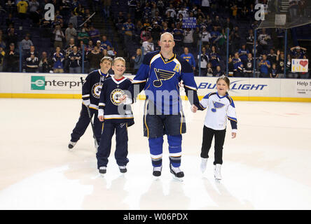 The family of St. Louis Blues Keith Tkachuk (L to R) Braeden, 10, Matthew,  12, Taryn, 7, and wife Chantal, listen during a press conference honoring  Tkachuk for his years of service