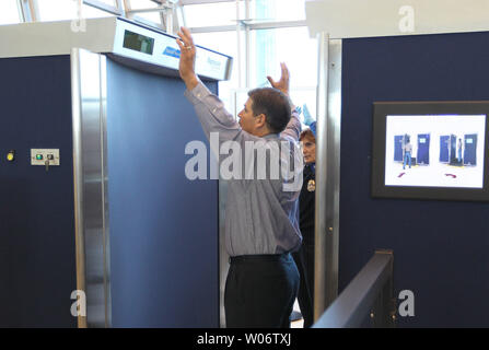 Airport worker Tom Crimi takes instructions from TSA worker Jan Ziegler ...