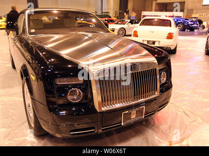 A 2011 Rolls-Royce Ghost with a Silver Satin finish hood waits to be placed and cleaned as work continues on the 2011 St. Louis Auto Show at America's Center in St. Louis on January 26, 2011. The Rolls-Royce is one of hundreds of cars that will be on display when the show opens on January 27.    UPI/Bill Greenblatt Stock Photo