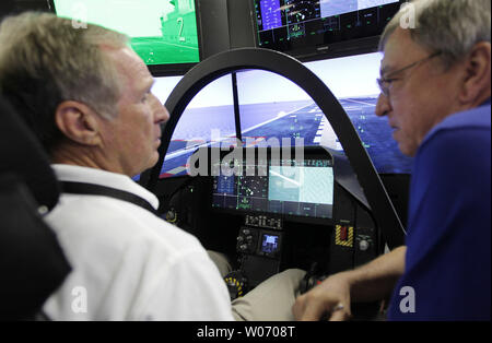 Col. Jack Jackson, a former Marine pilot, is guided onto the deck of an aircraft carrier by Lockheed simulator instructor Rick Royer of Fort Worth (R), during an inspection of its F-35 Lightning II mobile cockpit demonstrator to employees, state and local elected officials, other stakeholders in Earth City, Missouri on July 20, 2011. With 25 supplier locations in Missouri, the F-35 program currently provides approximately 525 direct and indirect jobs and generates nearly $35.5 million in economic impact across the state. The F-35 Lightning II is an advanced military aircraft. UPI/Bill Greenbla Stock Photo