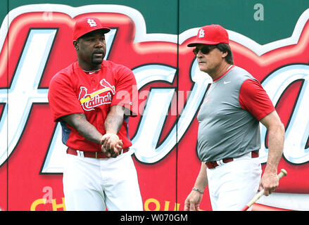Newly acquired St. Louis Cardinals pitcher Arthur Rhodes meets  Strength/Cond. Coordinator Pete Prinzi during batting practice before a  game against the Colorado Rockies at Busch Stadium in St. Louis on August  12