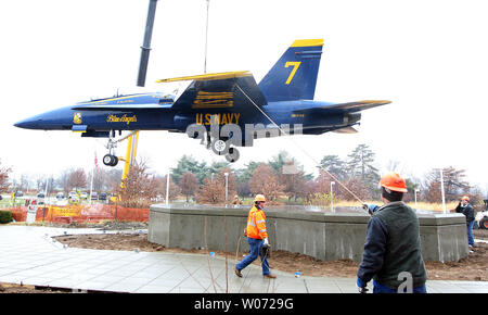 Workers steady a Blue Angel's jet as it is lowered into place  on a new display at the St. Louis Science Center in St. Louis on December 13, 2011. The Blue Angels F/A-18B Hornet  is on permanent loan from the National Naval Aviation Museum in Pensacola, Florida.    UPI/Bill Greenblatt Stock Photo