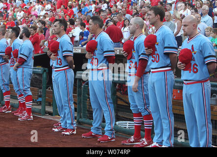 Members of the St. Louis Cardinals stand for a moment of silence for the  late New York Yankee Yogi Berra before a game against the Cincinnati Reds  at Busch Stadium in St.