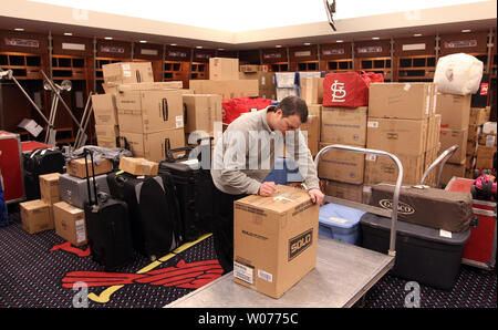 St. Louis Cardinals clubhouse attendant Nate Pfitzer moves boxes and luggage  from the team locker room at Busch Stadium in St. Louis to a waiting truck  as they prepare to leave for