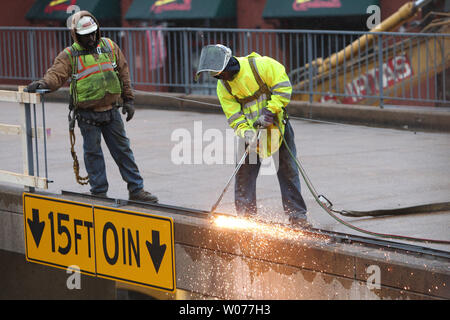 Constructions worker use a welding torch to remove railing on the Eighth Street bridge as demolition crews begin to remove the last landmark of the old Busch Stadium in St. Louis on March 9, 2013. Crews are clearing the bridge and surrounding areas for the new Ballpark Village construction project.     UPI/Bill Greenblatt Stock Photo