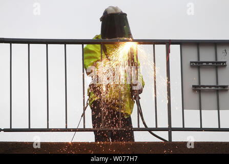 A construction worker uses a welding torch to remove railing on the Eighth Street bridge as demolition crews begin to remove the last landmark of the old Busch Stadium in St. Louis on March 9, 2013. Crews are clearing the bridge and surrounding areas for the new Ballpark Village construction project.     UPI/Bill Greenblatt Stock Photo