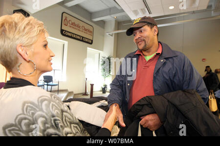 Brenda Warner, wife of former NFL quarterback Kurt Warner, presents former  Air Force member Robert Williams with his new jacket, during a coat  give-a-way in St. Louis on November 11, 2014. Warners