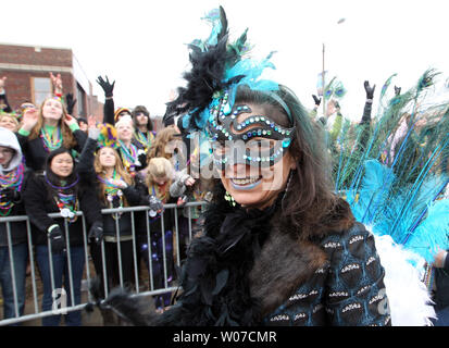 A woman wearing a mask throws beads to the parade goers during the Mardi Gras parade in St. Louis on March 1, 2014. UPI/Bill Greenblatt Stock Photo