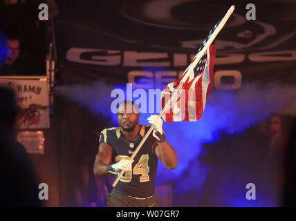 St. Louis Rams Robert Quinn runs onto the field with an American flag as he is introduced before a game against the Denver Broncos at the Edward Jones Dome in St. Louis on November 16, 2014. UPI/Bill Greenblatt Stock Photo