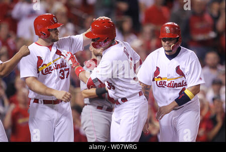 St. Louis Cardinals Aledmys Diaz retrieves a Jose Fernandez shirt that hung  in the dugout for their game against the Cincinnati Reds at Busch Stadium  in St. Louis on September 27, 2016.