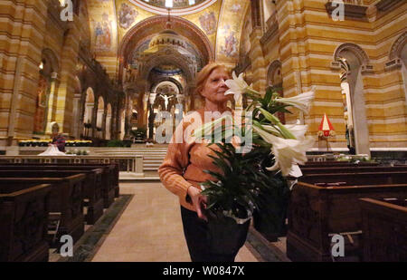 Volunteer Pat Rice walks with lillies at the Cathedral Basilica of St. Louis in St. Louis on March 31, 2018. Flowers that include, roses, lillies, snap dragons, and olive branches are being placed throughout the Basilica in preperation for the Easter celebration on April 1, 2018. Photo by Bill Greenblatt/UPI Stock Photo