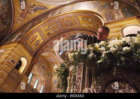 Florist Scott Hepper adjusts an adorment for the Ambo at the Cathedral Basilica of St. Louis in St. Louis on March 31, 2018. Flowers that include, roses, lillies, snap dragons, and olive branches are being placed throughout the Basilica in preperation for the Easter celebration on April 1, 2018. Photo by Bill Greenblatt/UPI Stock Photo