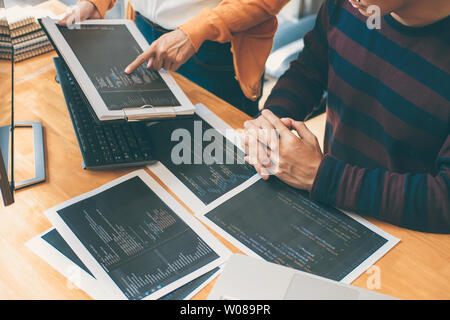 Professional Development programmer cooperating meeting and brainstorming and programming website working in a software and coding technology, writing Stock Photo