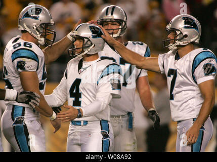 Carolina Panthers place kicker John Kasay, center, is consloed by teammates  punter Jason Baker, left, and guard Mackenzy Bernadeau (73), right, ater  missing a field goal that would have won the game