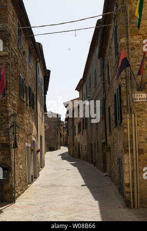 Narrow alley in the medieval village of Lucignano, with balconies and street lights. Tuscany, Italy. Stock Photo
