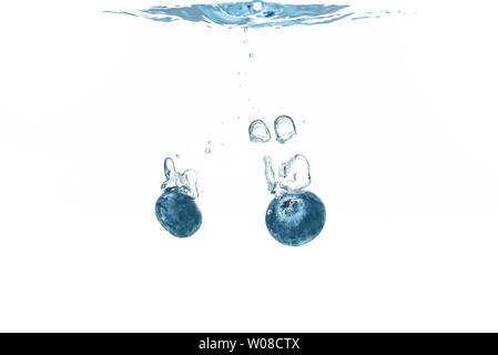 Two blueberry’s splashing into crystal clear water Stock Photo