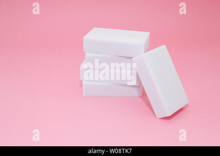 Melamine household sponge stack with four sponges for cleaning on pink background. Cleaning concept Stock Photo