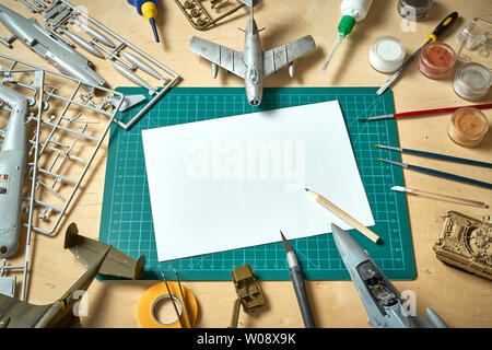 Top view on plastic model scale with accessories on  green pad on  wooden table Stock Photo