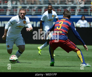 Manchester United's Wayne Rooney (L) drives on FC Barcelona's Gerard Pique (3) in the first half in the 2015 International Champions Cup North America at Levi's Stadium in Santa Clara, California on July 25, 2015. Manchester defeated Barcelona 3-1.  Photo by Terry Schmitt/UPI Stock Photo