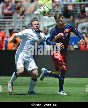 Manchester United's Wayne Rooney (L) fights for the ball with FC Barcelona's Gerard Pique (3) in the first half in the 2015 International Champions Cup North America at Levi's Stadium in Santa Clara, California on July 25, 2015. Manchester defeated Barcelona 3-1.  Photo by Terry Schmitt/UPI Stock Photo