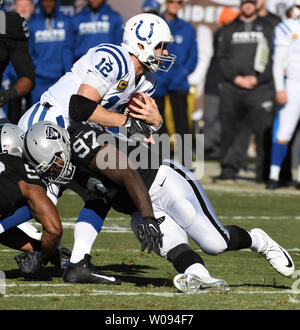 Indianapolis Colts QB Andrew Luck (12) runs against the Oakland Raiders Mario Edwards Jr. (97) in the first quarter at the Oakland Coliseum in Oakland, California on December 24, 2016. The Raiders won 33-25 but lost QB Derek Carr to a broken fibula.       Photo by Terry Schmitt/UPI Stock Photo