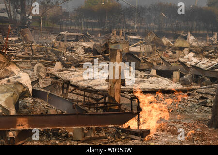 Live gas jets shoot up from the ruins of Journey's End Trailer Park after wildfires fueled by wind and low humidity destroyed it in Santa Rosa, California on October 9, 2017. Smoke filled the air as thousands of structures burned.   Photo by Terry Schmitt/UPI Stock Photo