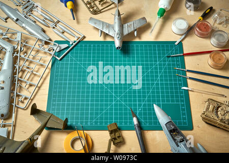 Top view on plastic model scale with accessories on  green pad on  wooden table Stock Photo