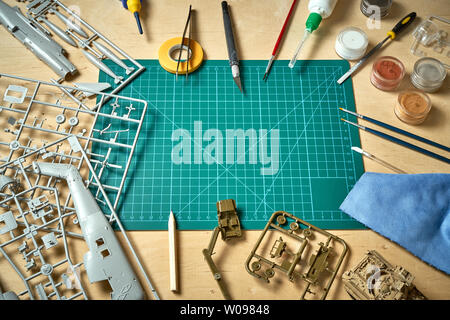 Top view on plastic model scale with accessories on  green pad on  wooden table Stock Photo