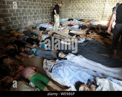 Dead children lie on the ground as Syrian rebels claim they were killed in a toxic gas attack by pro-government forces in eastern Ghouta, on the outskirts of Damascus in Syria on August 21, 2013. The Syrian government has denied the claims from the opposition that it has used chemical weapons. The UN is investigating.   UPI/Diaa El Din Stock Photo
