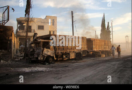 Syrians looks at the burning and damaged trucks, carrying aid after air strikes destroyed 18 lorries in a 31-truck aid convoy in the town of Orum al-Kubra on the western outskirts of the northern Syrian city of Aleppo on, September 20, 2016. The Red Cross said on Tuesday at least 20 people were killed in the attack on the trucks carrying desperately needed humanitarian relief to thousands of Syrians. photo by Omar Haj Kadour/ UPI Stock Photo