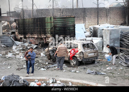 Syrians looks at the burning and damaged trucks, carrying aid after air strikes destroyed 18 lorries in a 31-truck aid convoy in the town of Orum al-Kubra on the western outskirts of the northern Syrian city of Aleppo on, September 20, 2016. The Red Cross said on Tuesday at least 20 people were killed in the attack on the trucks carrying desperately needed humanitarian relief to thousands of Syrians. photo by Omar Haj Kadour/ UPI Stock Photo