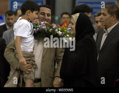 Iranian nuclear scientist Shahram Amiri arrives and is greeted by relatives and friends after arriving at Imam Khomeini airport in Tehran, Iran on July 15, 2010.  He is holding his 7-year-old son Amir Hossein.  Amiri claimed he was adducted by American agents last year while the U.S. says he was a willing defector who changed his mind.       UPI/Maryam Rahmanian Stock Photo