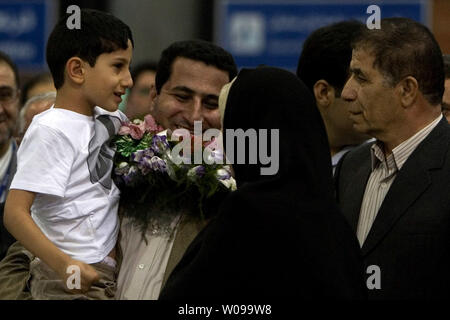 Iranian nuclear scientist Shahram Amiri arrives and is greeted by relatives and friends after arriving at Imam Khomeini airport in Tehran, Iran on July 15, 2010.  He is holding his 7-year-old son Amir Hossein.  Amiri claimed he was adducted by American agents last year while the U.S. says he was a willing defector who changed his mind.       UPI/Maryam Rahmanian Stock Photo