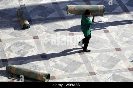 An Iranian man carries prayer rug after they finish with Eid-Al- Fitr prayers at Imam zadeh Helal Ebne Ali shrine in Aran o BidGol on Aug 31,2011. Aran o BidGol  is  a city in Isfahan province, located about 250 KM south of Tehran, Iran . The Eid-al-Fitr festival marks the end of the holy Muslim fasting month of Ramadan.      UPI/Maryam Rahmanian Stock Photo