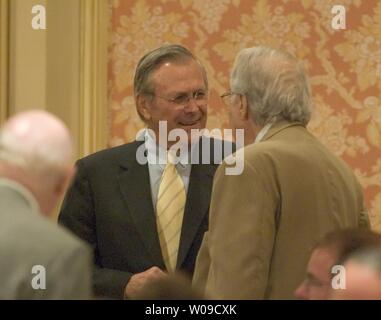 Secretary of Defense Donald Rumsfeld (C) is greeted by business leaders as he arrives to speaks to a joint meeting of the Chicago Council on Foreign Relations and the Commercial Club of Chicago. Rumsfeld gave an assessment of the U.S. progress in Iraq and Afghanistan on Friday, August 6, 2004 in Chicago, Illinois.  (UPI Photos/Tannen Maury) Stock Photo
